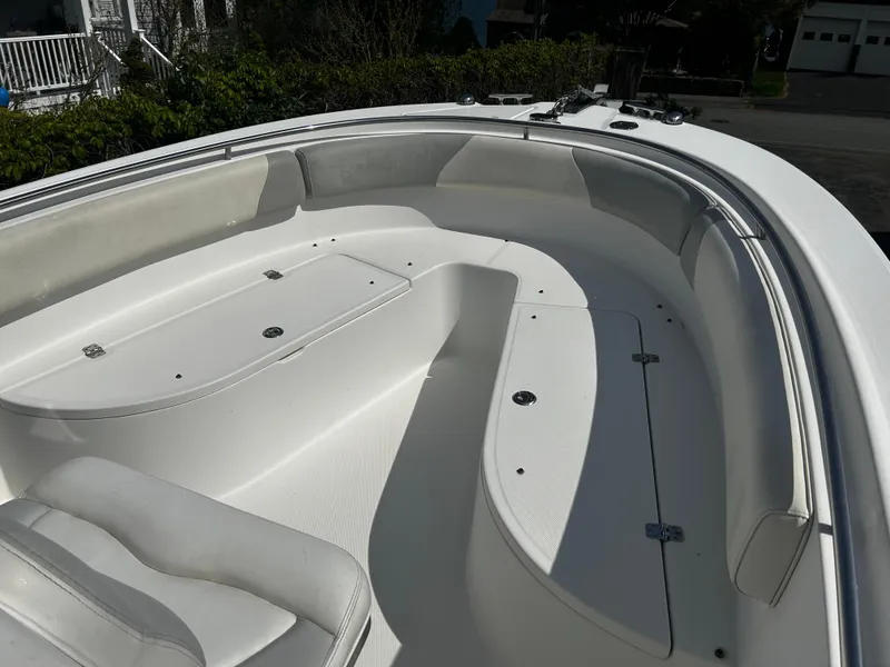 Slide: The Image of 2010 Edgewater 228CC boat interior with white seating and storage compartments. - 21