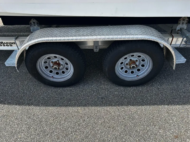 Slide: The Image of Trailer wheels of a 2010 Edgewater 228CC boat on asphalt surface. - 22