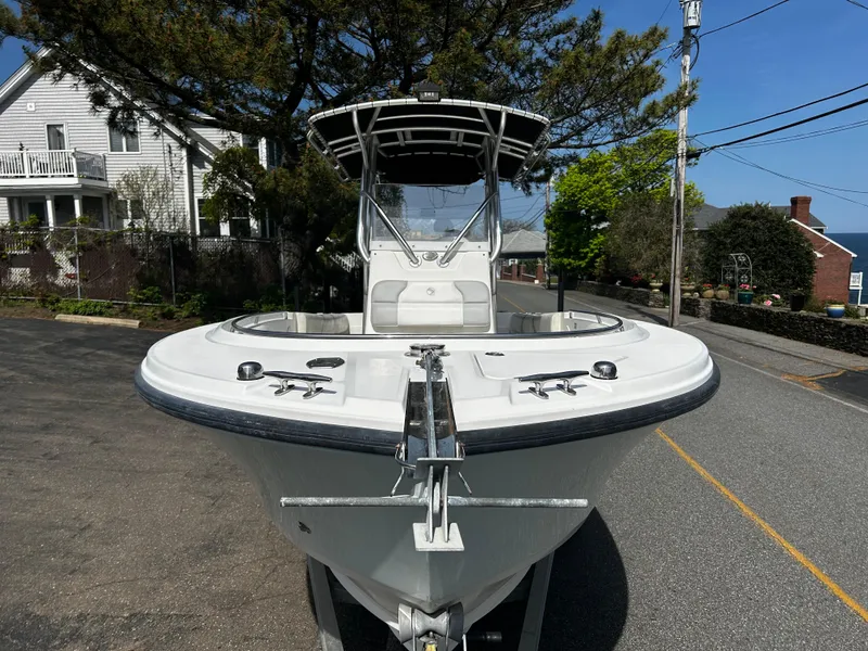 Slide: The Image of 2010 Edgewater 228CC boat parked on a street, front view with clear sky background. - 3