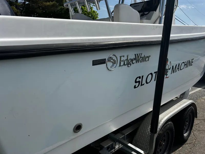 Slide: The Image of Edgewater 228CC 2010 boat on trailer, side view with "Slot Machine" text. - 7