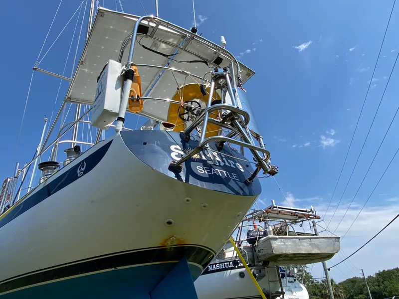 Slide: The Image of 1972 Ericson 39 Flushdeck sailboat on land, blue sky background. - 19