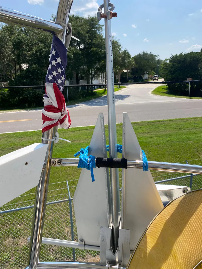 Slide: The Image of 1972 Ericson 39 Flushdeck sailboat with American flag and blue rope, docked near a road. - 27