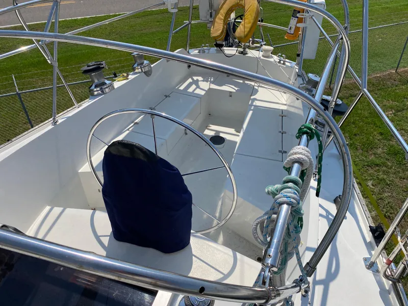 Slide: The Image of 1972 Ericson 39 Flushdeck sailboat cockpit with steering wheel and ropes. - 34