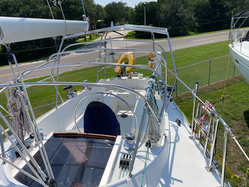 Slide: The Image of 1972 Ericson 39 Flushdeck sailboat with clean deck and rigging, docked near a road. - 38