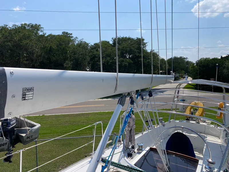 Slide: The Image of 1972 Ericson 39 Flushdeck sailboat with mast and rigging, docked near trees. - 39