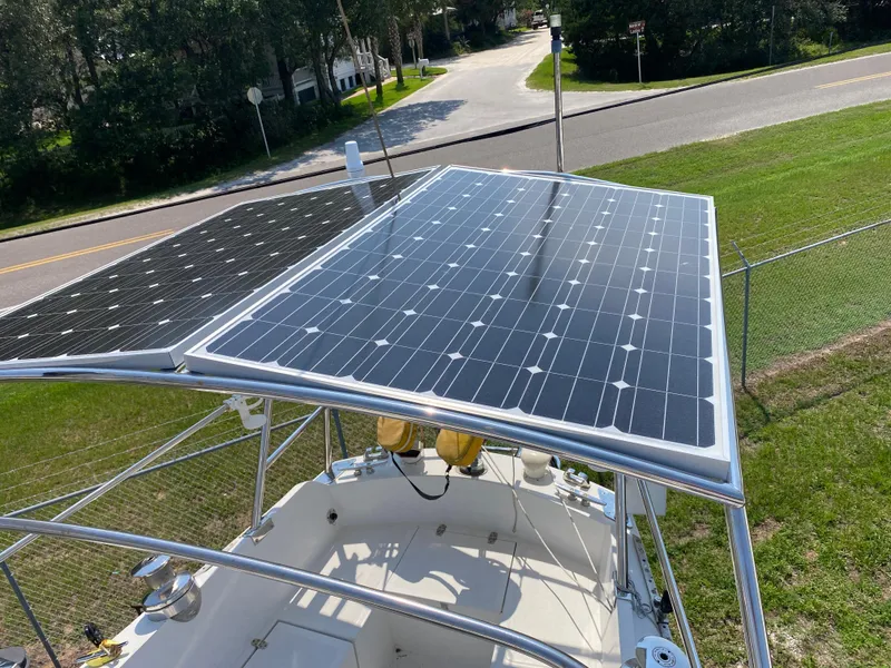 Slide: The Image of Ericson 39 Flushdeck 1972 sailboat with solar panels on deck, near a road. - 51