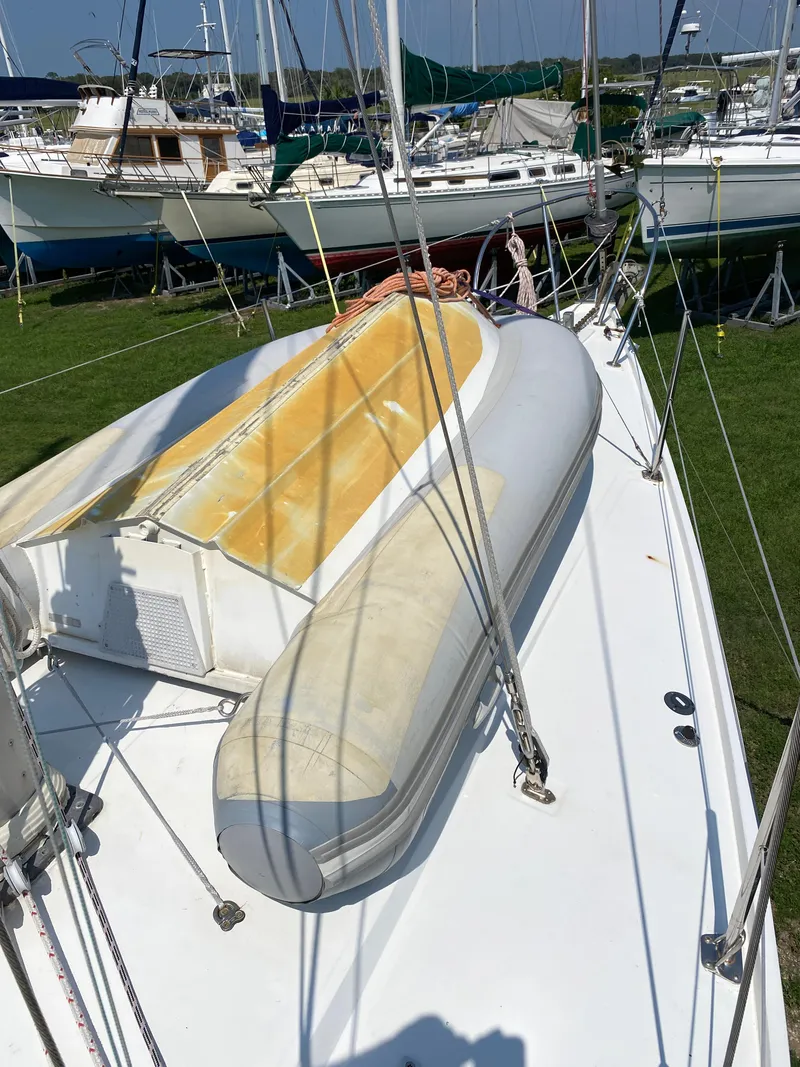 Slide: The Image of 1972 Ericson 39 Flushdeck sailboat with inflatable dinghy on deck, docked in a marina. - 56