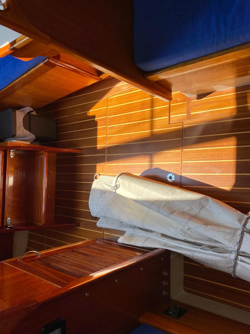 Slide: The Image of Interior of 1972 Ericson 39 Flushdeck sailboat with wooden paneling and blue cushions. - 76