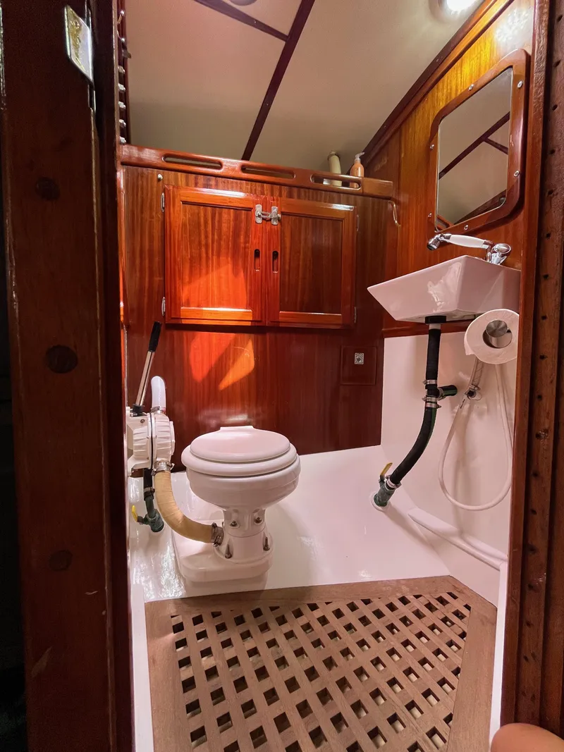 Slide: The Image of 1972 Ericson 39 Flushdeck yacht bathroom with wooden cabinetry and marine toilet. - 78