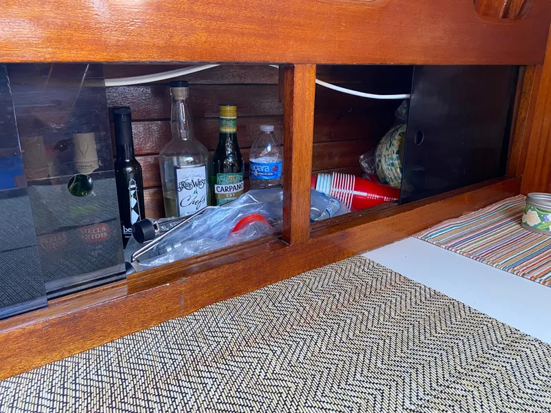 Slide: The Image of Wooden cabinet with assorted bottles and items on Ericson 39 Flushdeck, 1972 model. - 80