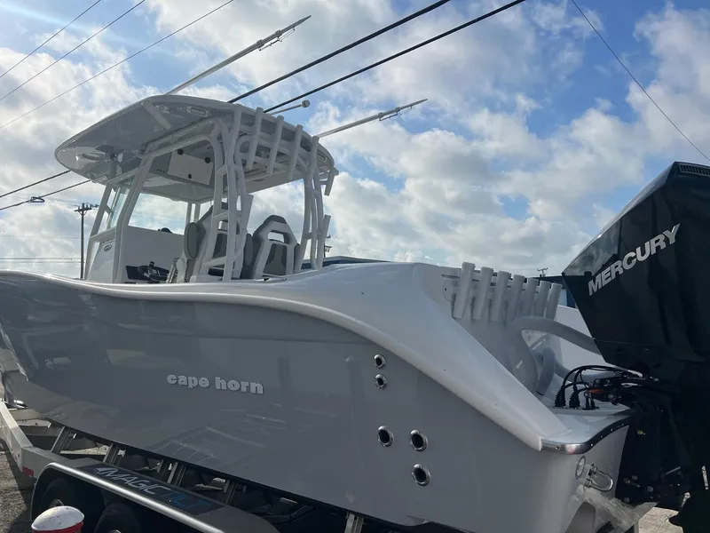 Slide: The Image of 2024 Cape Horn 32xs boat with Mercury engine under a cloudy sky. - 2