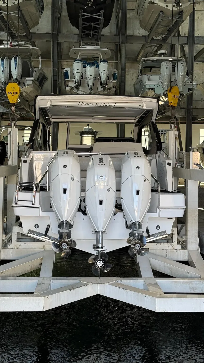 Slide: The Image of Schaefer 375 boat with triple outboard engines in a storage facility, 2025 model. - 2
