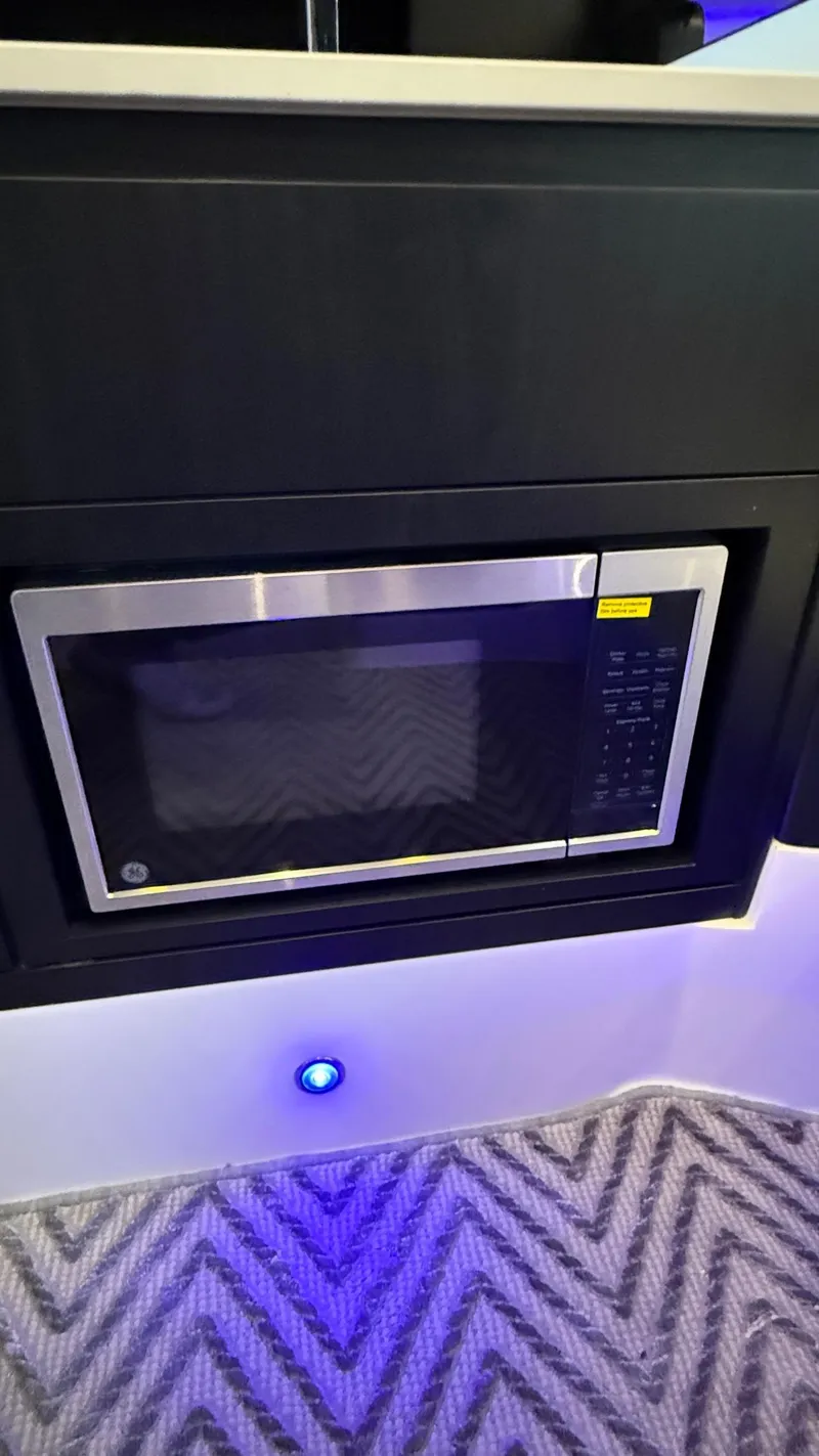 Slide: The Image of Built-in microwave in Schaefer 375 yacht, 2025 model, with modern design and blue LED lighting. - 48