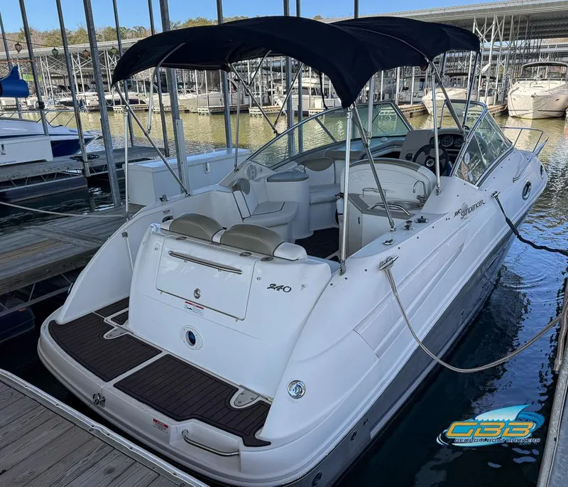 Slide: The Image of 2007 Sea Ray 240 Sundancer boat docked with black canopy and white interior. - 10