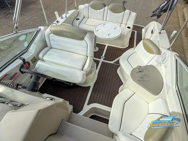 Slide: The Image of 2007 Sea Ray 240 Sundancer boat interior with white seating and wood flooring. - 14
