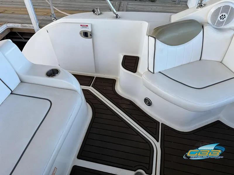 Slide: The Image of 2007 Sea Ray 240 Sundancer interior with white seating and dark flooring. - 18