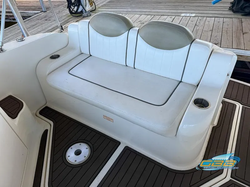 Slide: The Image of 2007 Sea Ray 240 Sundancer boat seating area with white upholstery and cup holders. - 20