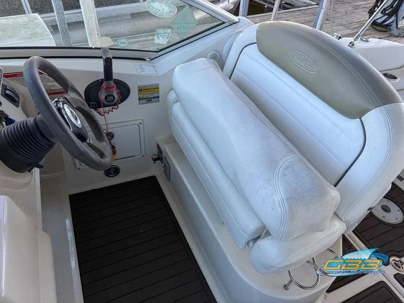 Slide: The Image of 2007 Sea Ray 240 Sundancer helm with white seating and steering wheel. - 21