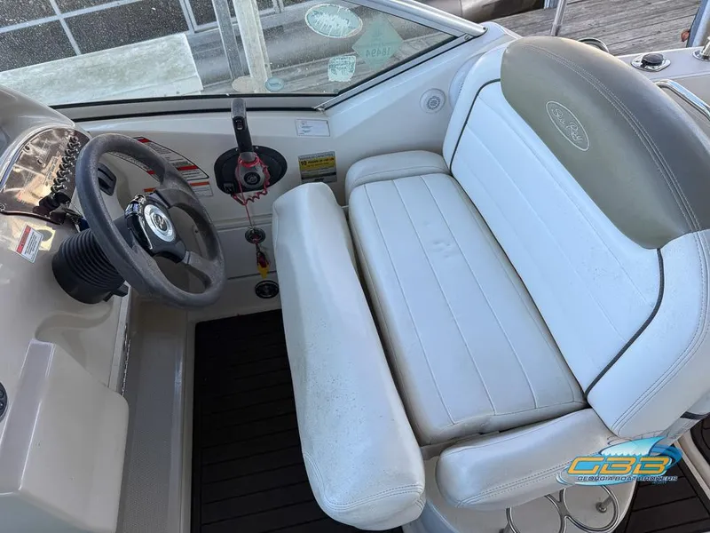 Slide: The Image of 2007 Sea Ray 240 Sundancer helm with white seating and steering wheel. - 22