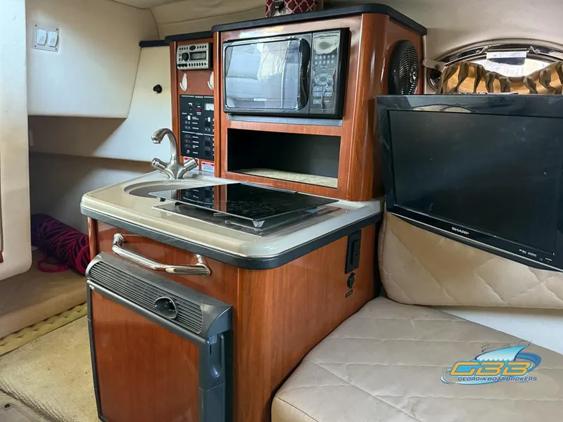 Slide: The Image of 2007 Sea Ray 240 Sundancer cabin with kitchenette, microwave, and TV. - 29