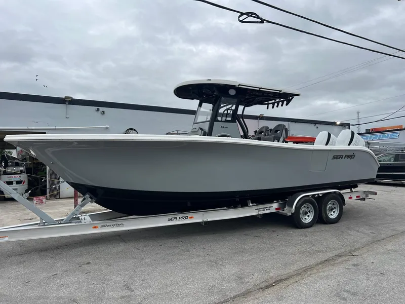 The Image of 2025 Sea Pro 292 boat on trailer, gray hull, overcast sky. - 0