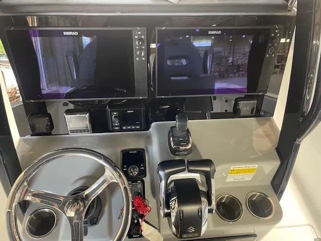 Slide: The Image of 2025 Sea Pro 292 boat dashboard with dual Simrad displays and steering wheel. - 5