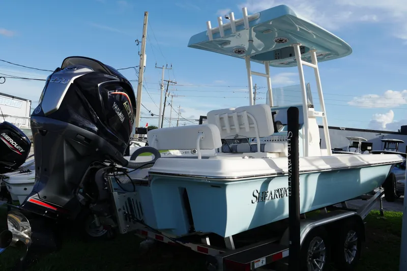 The Image of 2025 ShearWater 23LTZ boat with Yamaha engine on trailer, under clear blue sky. - 0