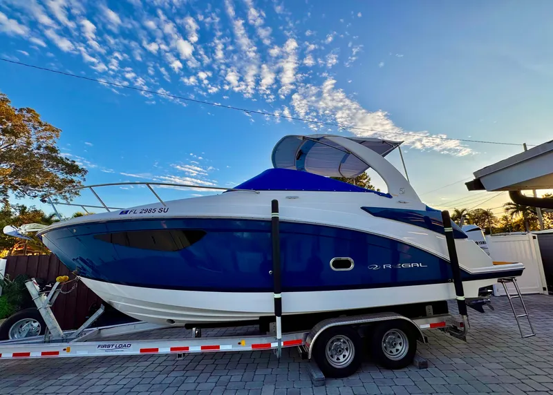 The Image of 2020 Regal 26XO boat on trailer under a vibrant sky. - 0