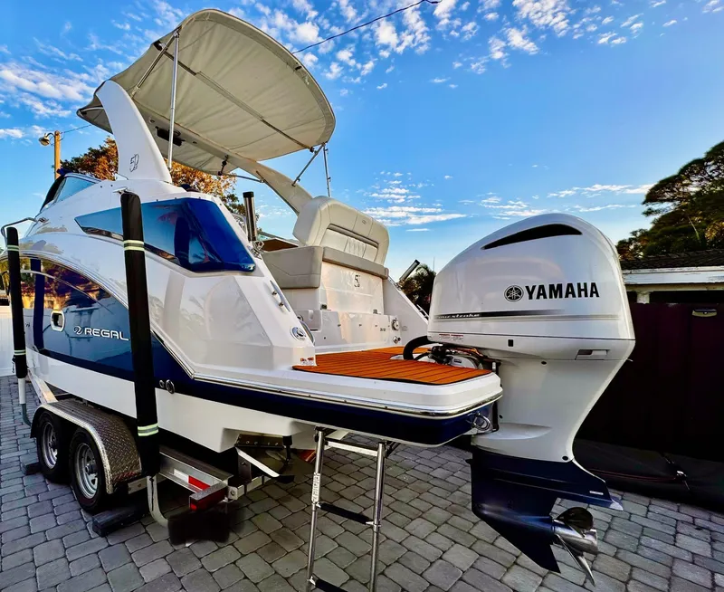 Slide: The Image of 2020 Regal 26XO boat with Yamaha outboard engine on trailer, under a clear sky. - 10