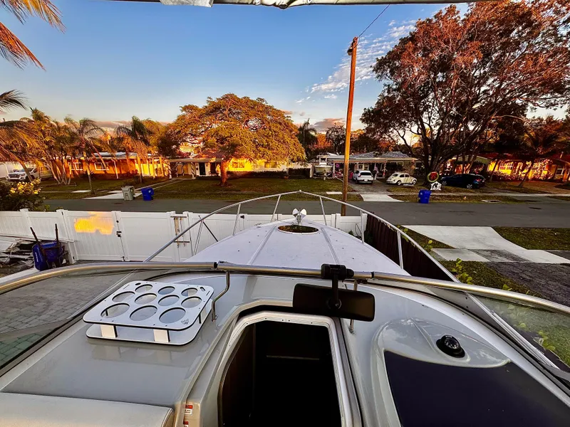 Slide: The Image of 2020 Regal 26XO boat docked, surrounded by trees and houses at sunset. - 26