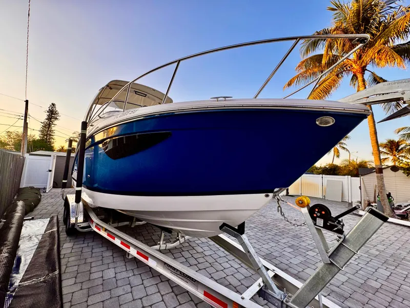 Slide: The Image of 2020 Regal 26XO boat on trailer, blue hull, parked on paved driveway. - 3