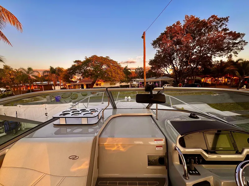 Slide: The Image of 2020 Regal 26XO boat interior with sunset view, featuring dashboard and seating area. - 4