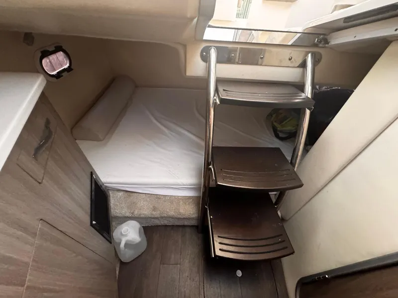 Slide: The Image of 2020 Regal 26XO cabin interior with bed, ladder, and wooden flooring. - 48
