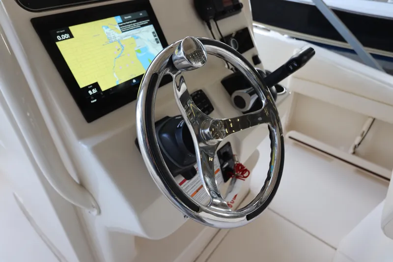 Slide: The Image of 2024 Grady-White Fisherman 216 boat dashboard with steering wheel and navigation display. - 20