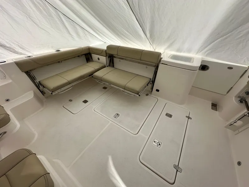 Slide: The Image of 2017 Pursuit OS 355 Offshore boat interior with beige seating and storage compartments. - 13