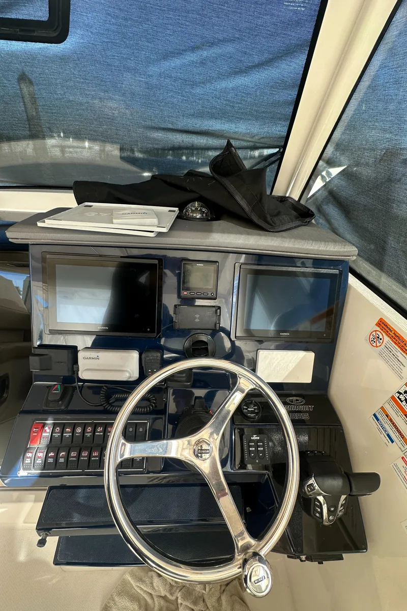 Slide: The Image of 2017 Pursuit OS 355 Offshore helm with steering wheel and navigation controls. - 31