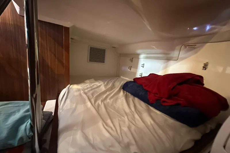 Slide: The Image of Cozy cabin interior of 2017 Pursuit OS 355 Offshore boat with bed and pillows. - 32