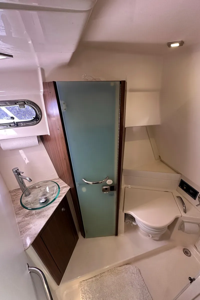 Slide: The Image of 2017 Pursuit OS 355 Offshore boat bathroom with modern fixtures and glass sink. - 33
