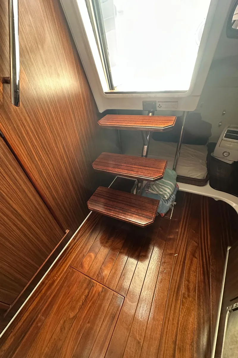 Slide: The Image of Interior of 2017 Pursuit OS 355 Offshore with wooden steps and flooring. - 34