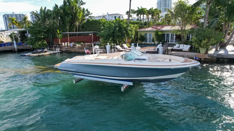 The Image of 2014 Chris-Craft Launch 32 boat docked by waterfront home. - 1