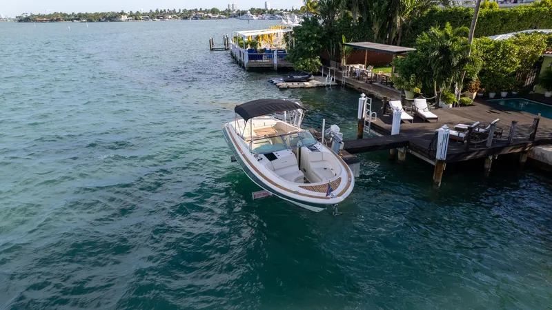 Slide: The Image of 2014 Chris-Craft Launch 32 boat docked by a scenic waterfront. - 14