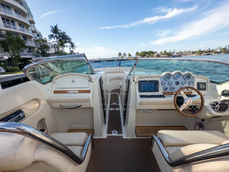 Slide: The Image of 2014 Chris-Craft Launch 32 boat interior with dashboard and steering wheel, docked by waterfront. - 17