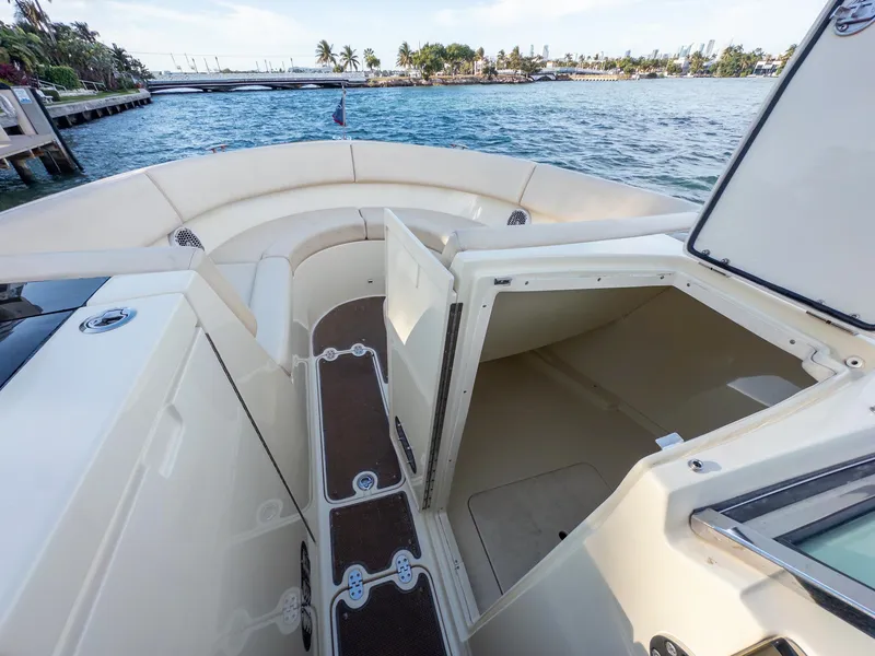 Slide: The Image of 2014 Chris-Craft Launch 32 boat interior with open storage compartments, docked by the water. - 25
