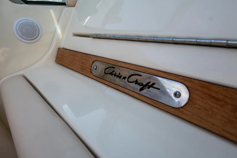 Slide: The Image of Chris-Craft Launch 32 interior detail, showcasing wood trim and branded metal plate, 2014 model. - 32