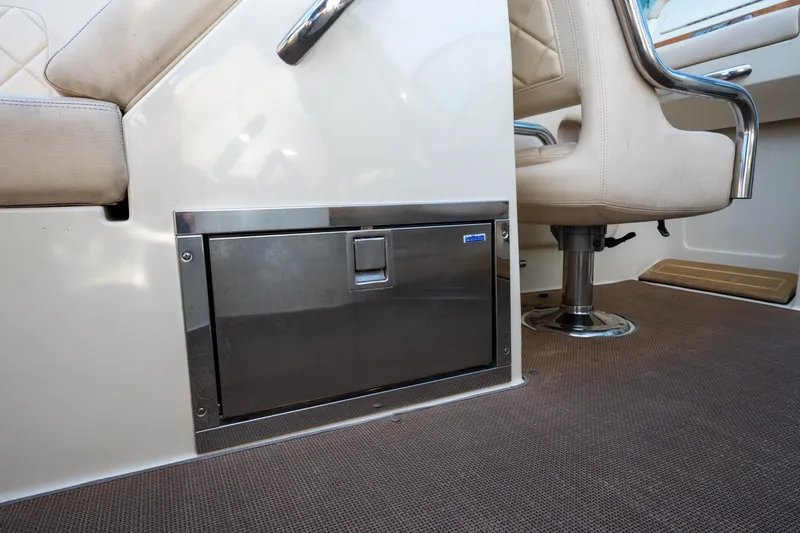Slide: The Image of 2014 Chris-Craft Launch 32 interior with stainless steel storage compartment and beige seating. - 33