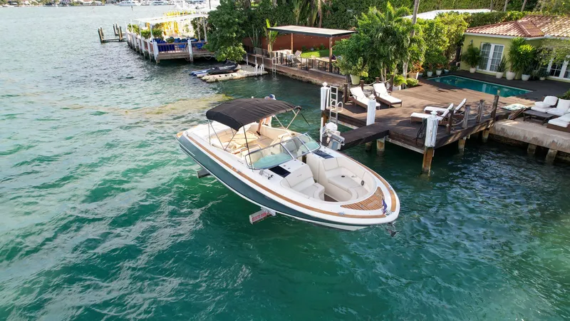 Slide: The Image of 2014 Chris-Craft Launch 32 boat docked by a luxurious waterfront property. - 9
