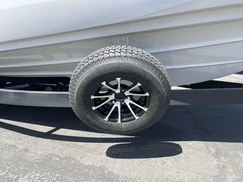 Slide: The Image of 2025 Yamaha Boats AR250 trailer tire and wheel on pavement. - 18
