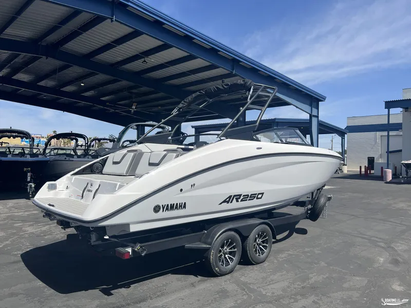 Slide: The Image of 2025 Yamaha AR250 boat on trailer under a metal canopy. - 2