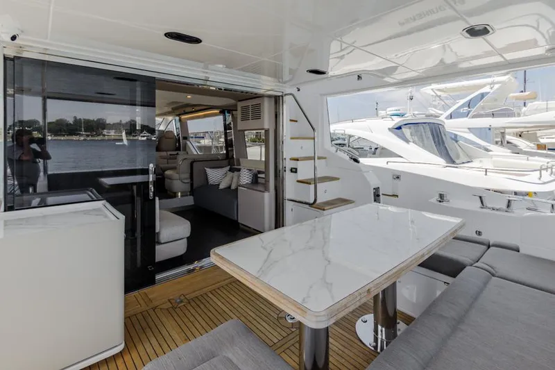 Slide: The Image of Azimut 60 Flybridge 2021 yacht interior with elegant seating and dining area. - 15