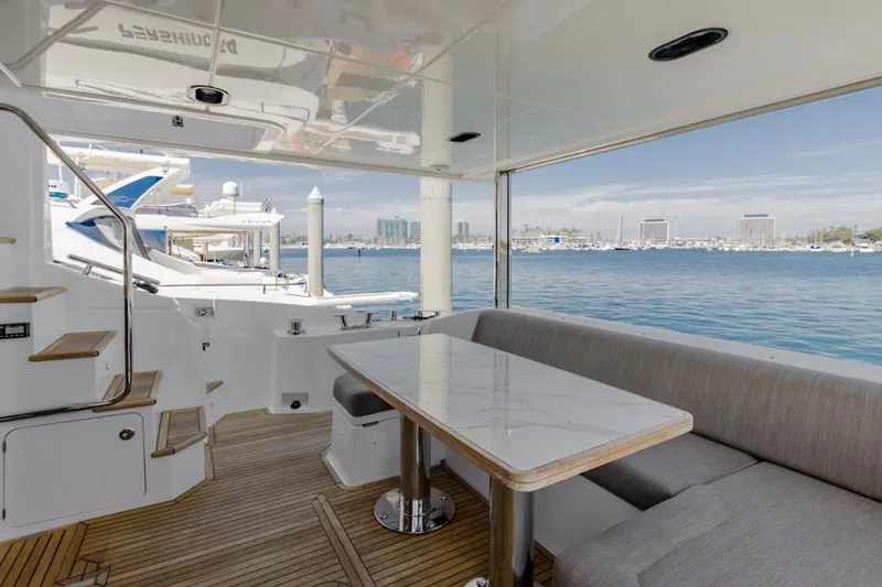 Slide: The Image of Azimut 60 Flybridge 2021 yacht with elegant outdoor seating and scenic marina view. - 16